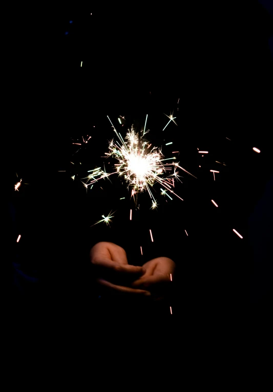 people hold sparklers up to the sky in front of them