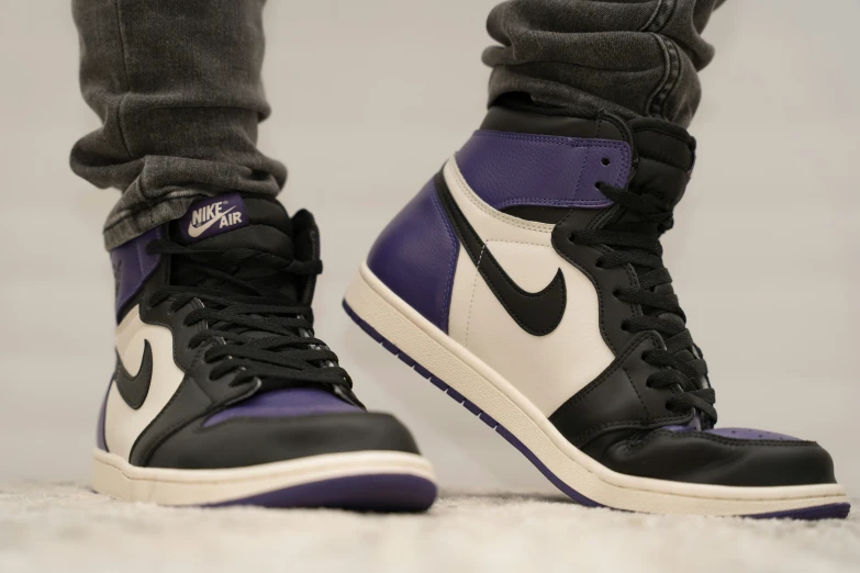 the legs of a man in a pair of black and purple sneakers