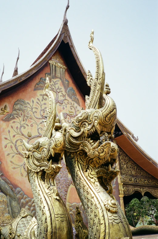 two golden asian garuds in front of a building