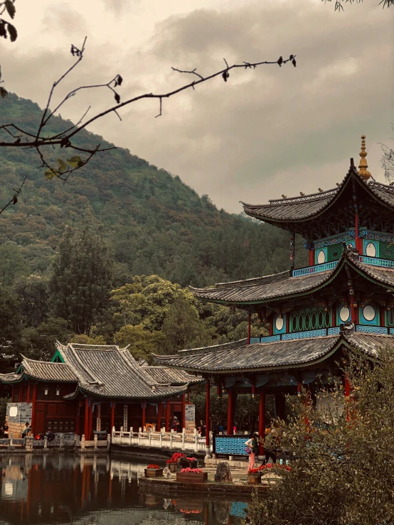 a building in front of some hills on a cloudy day