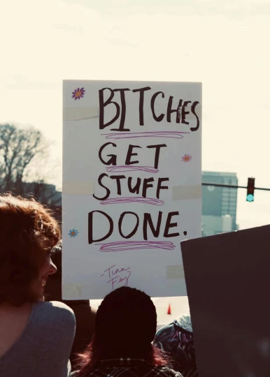 a person holding a protest sign with writing