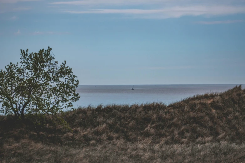 a lone boat on the ocean, under a partly cloudy sky