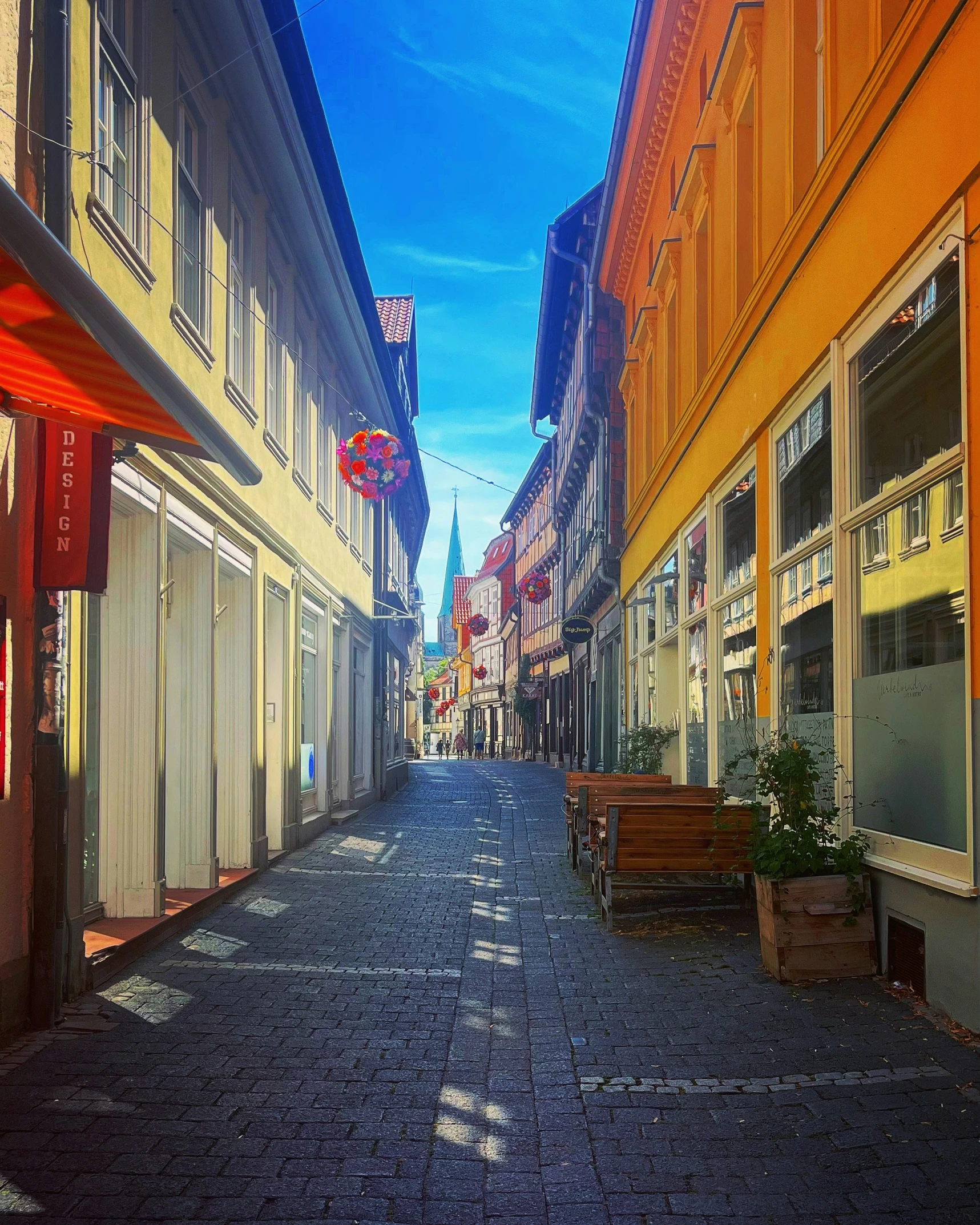 a city alleyway with benches and buildings