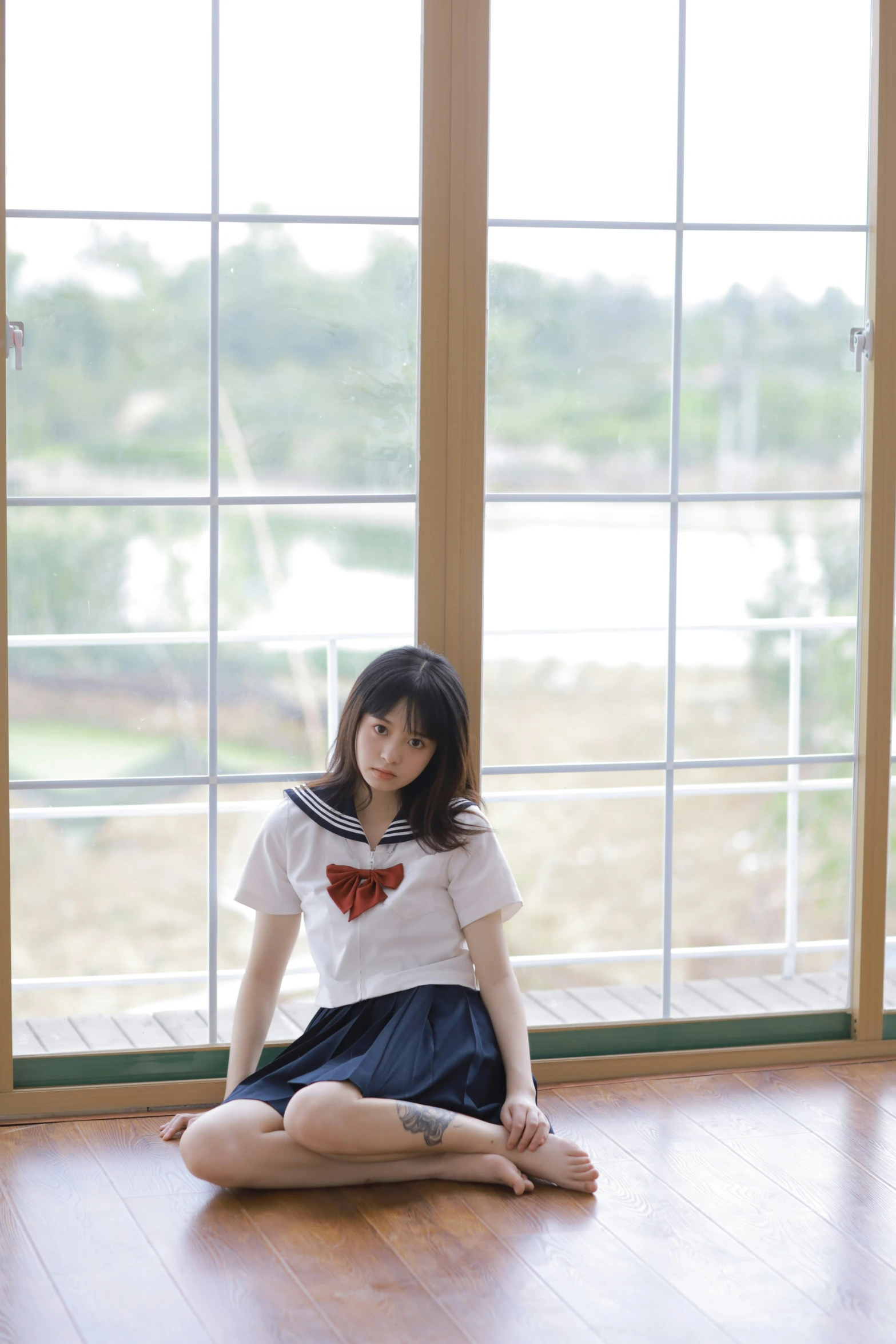 a beautiful woman sitting in the middle of a wooden floor