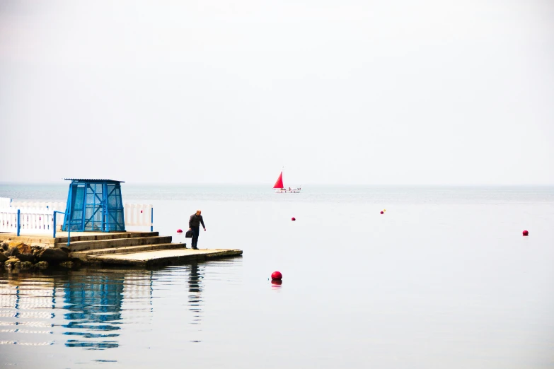 a man stands on a ledge looking out to the water