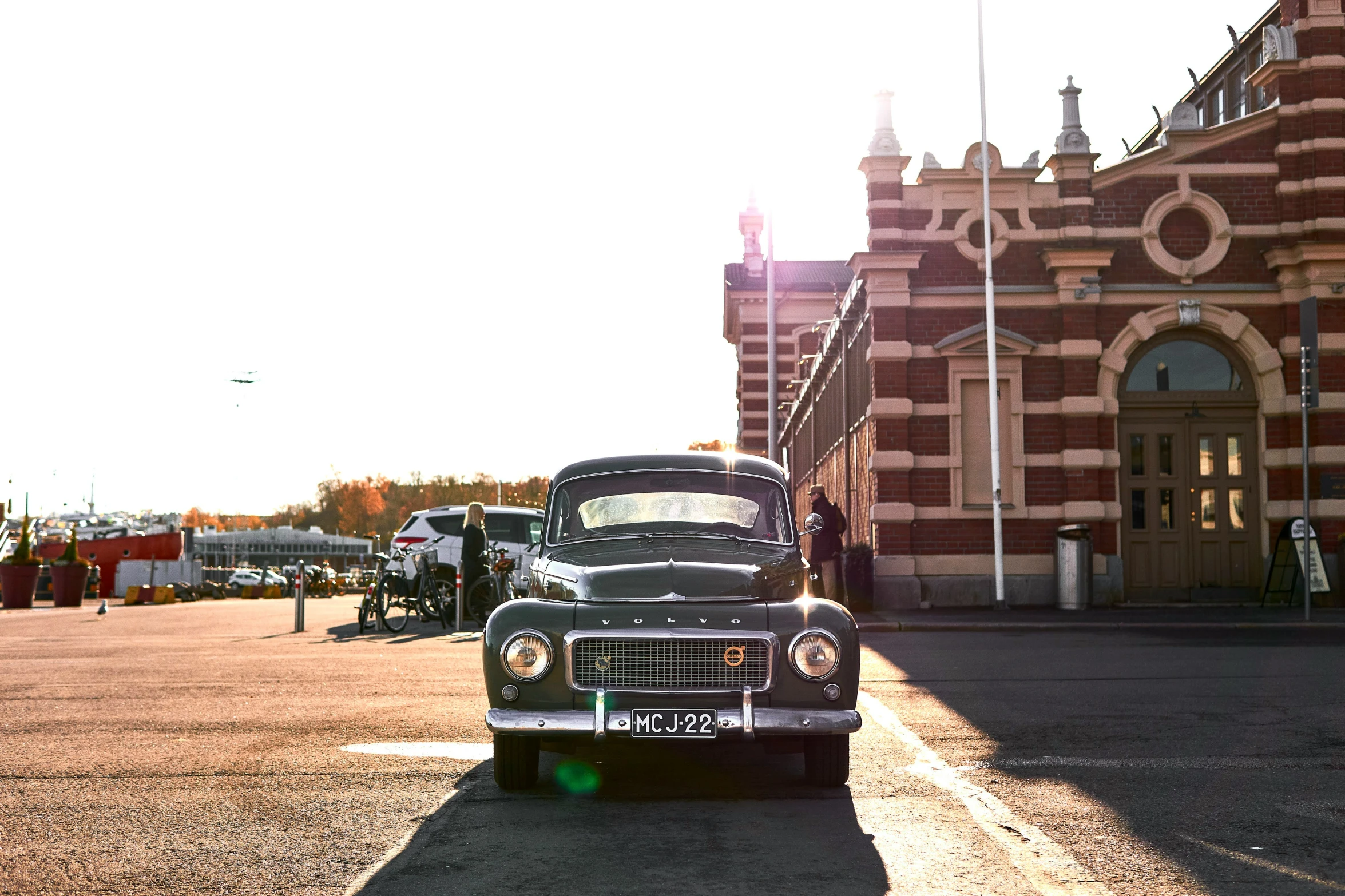 an old car is parked outside of a large building