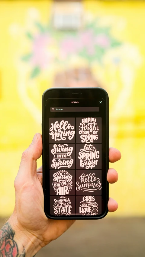 a person holding a phone with the back side of it showing a screen displaying a list of the five types of lettering