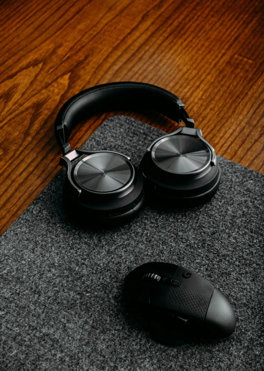 a pair of headphones and a computer mouse are sitting on a black surface