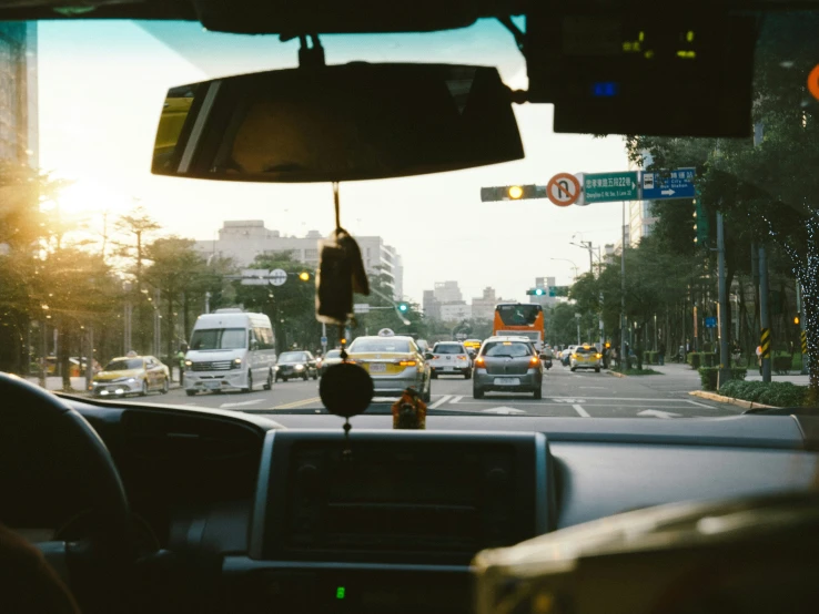 the inside view of a driver's seat with a city in the background