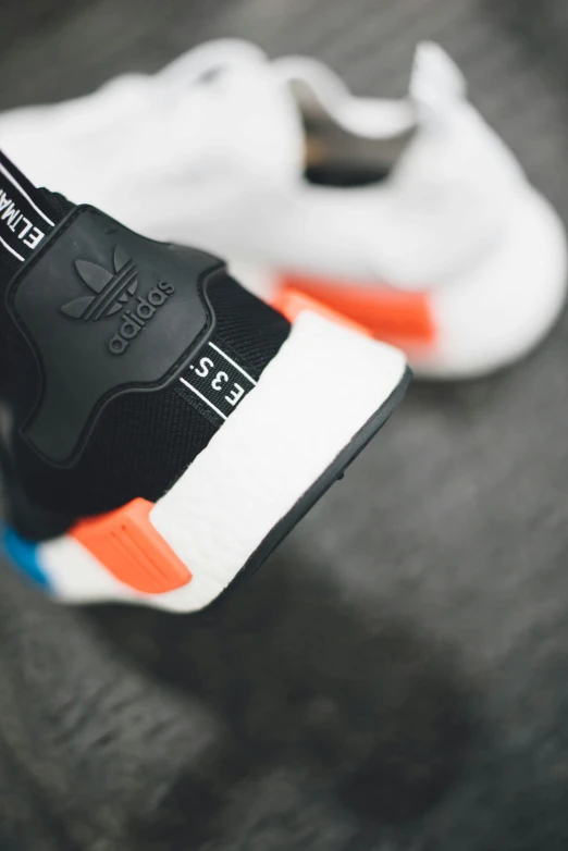 a black and orange adidas sneaker is on top of a table