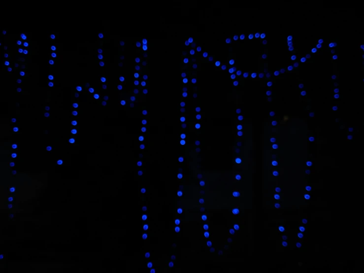 a dark night with blue lights in the shape of letters