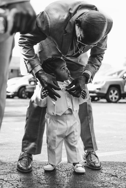 the small child is being carried by the man in the suit