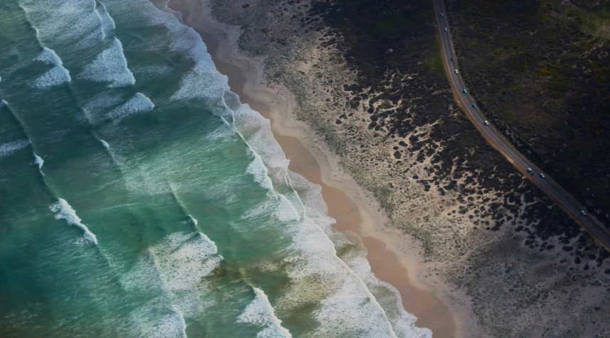 an overhead view of a road near the ocean