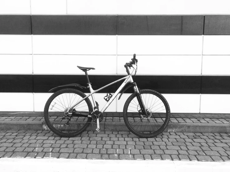 a white bike leaning against the side of a wall