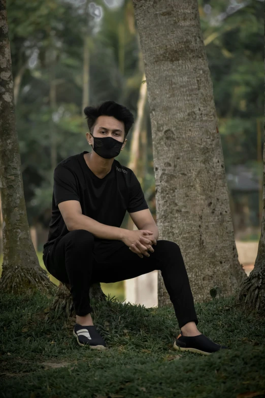 a man with his face painted black and sitting on the ground