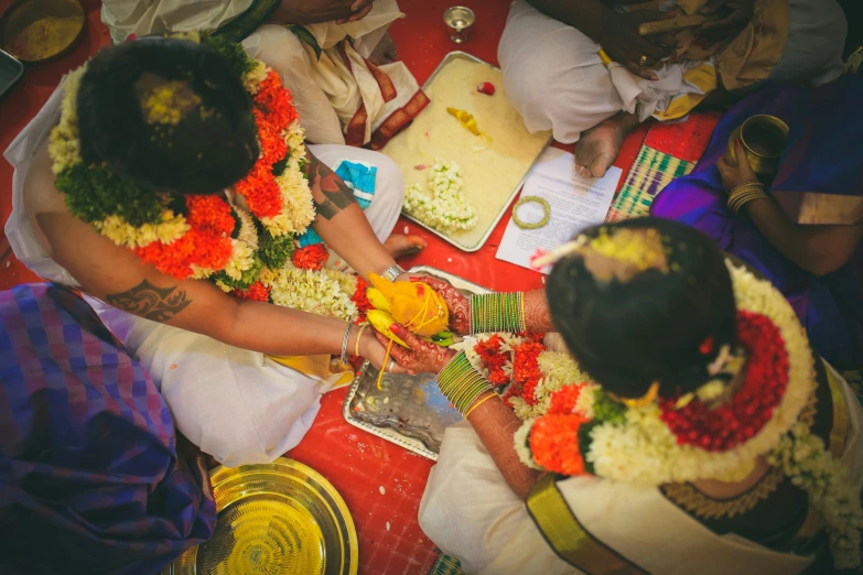 two women who are  flowers on a table