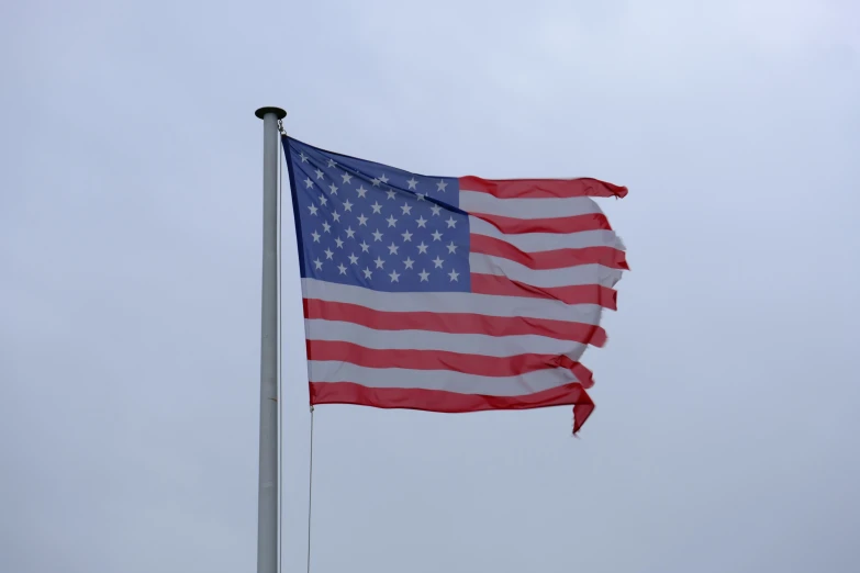 an american flag on a pole waving in the wind