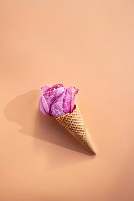 the ice cream cone has a pink rose in it