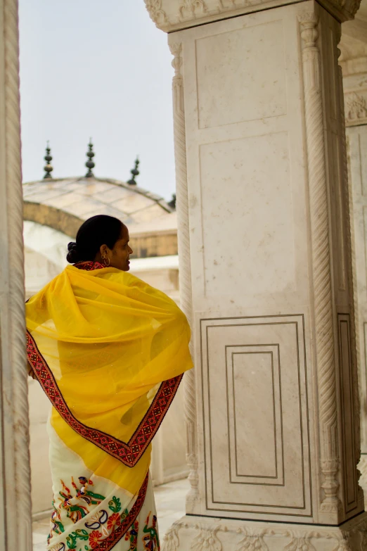 the woman wearing a yellow scarf is looking out