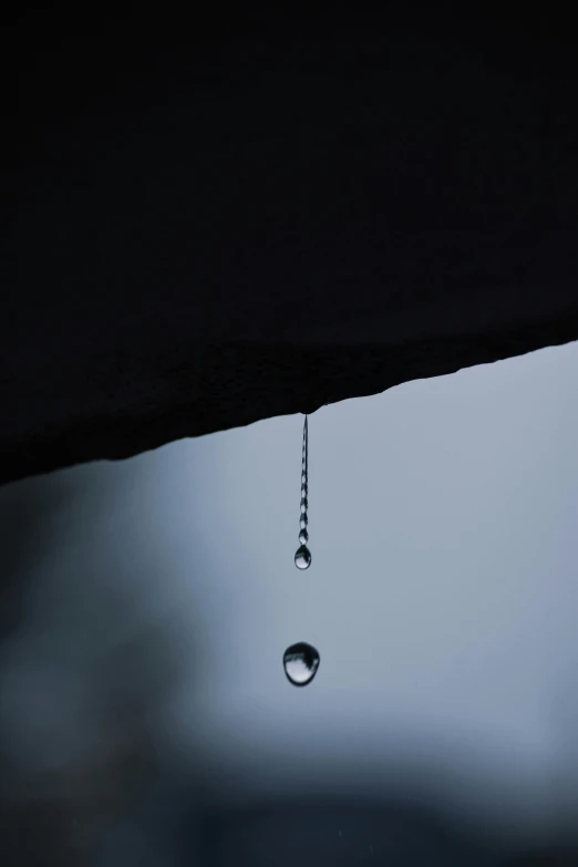 a drop of rain falling from a roof