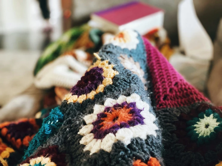 colorful crocheted blankets are set on a table