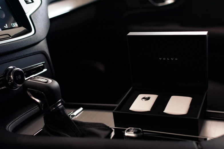 an elegant new iphone box sitting on the dashboard of a car