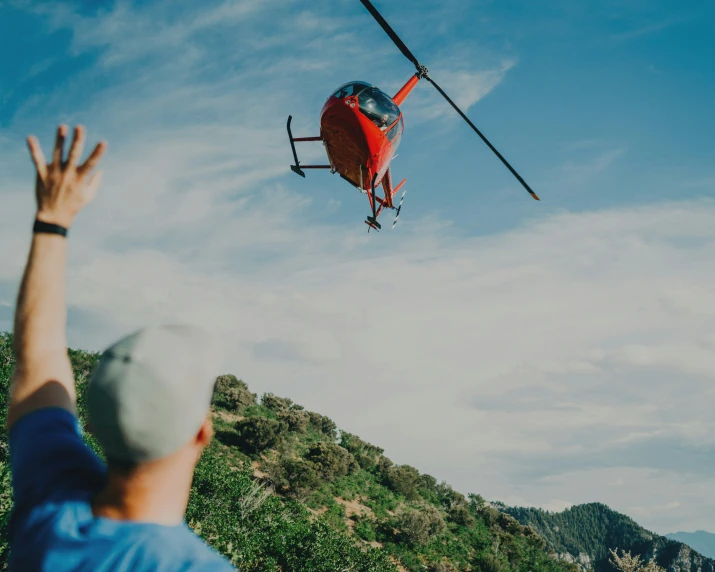 a man waves to an airplane that is flying high