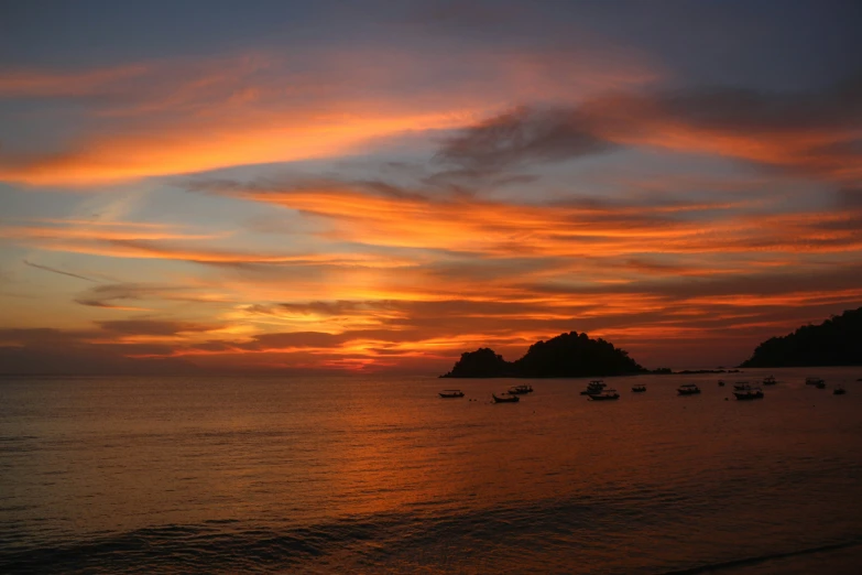 several boats are out on the water at sunset