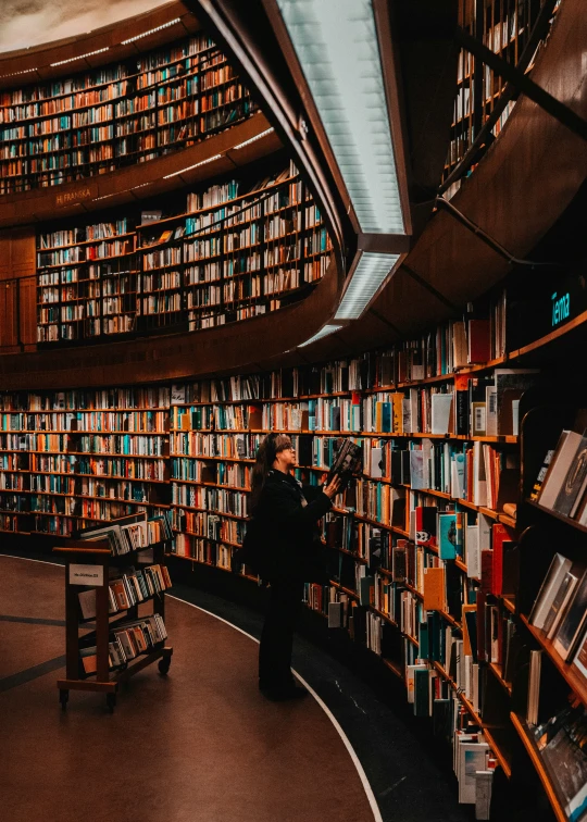 a person walking through a liry filled with books