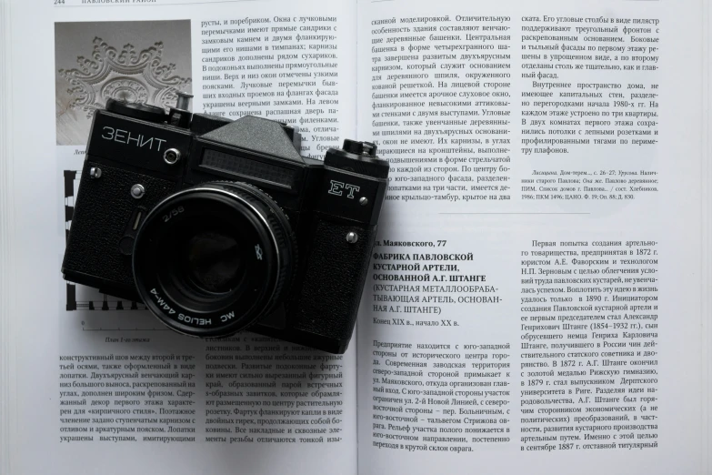 an old camera resting on a page of a book