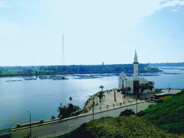 there is a small white church sitting at the edge of the lake