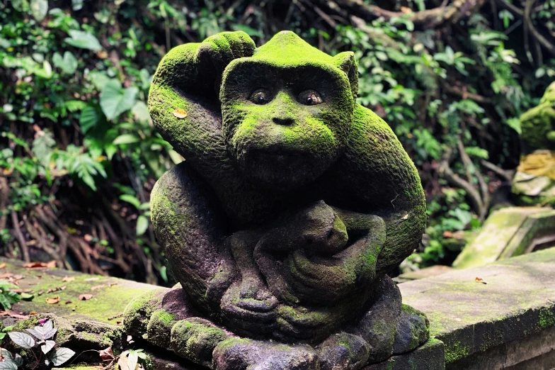 a statue in the middle of an outdoor display of trees and vegetation