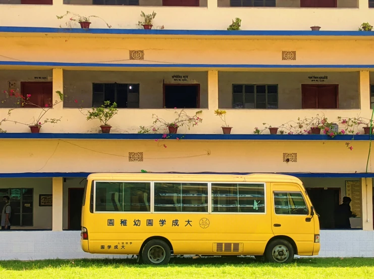 the yellow bus has flowers in the planters