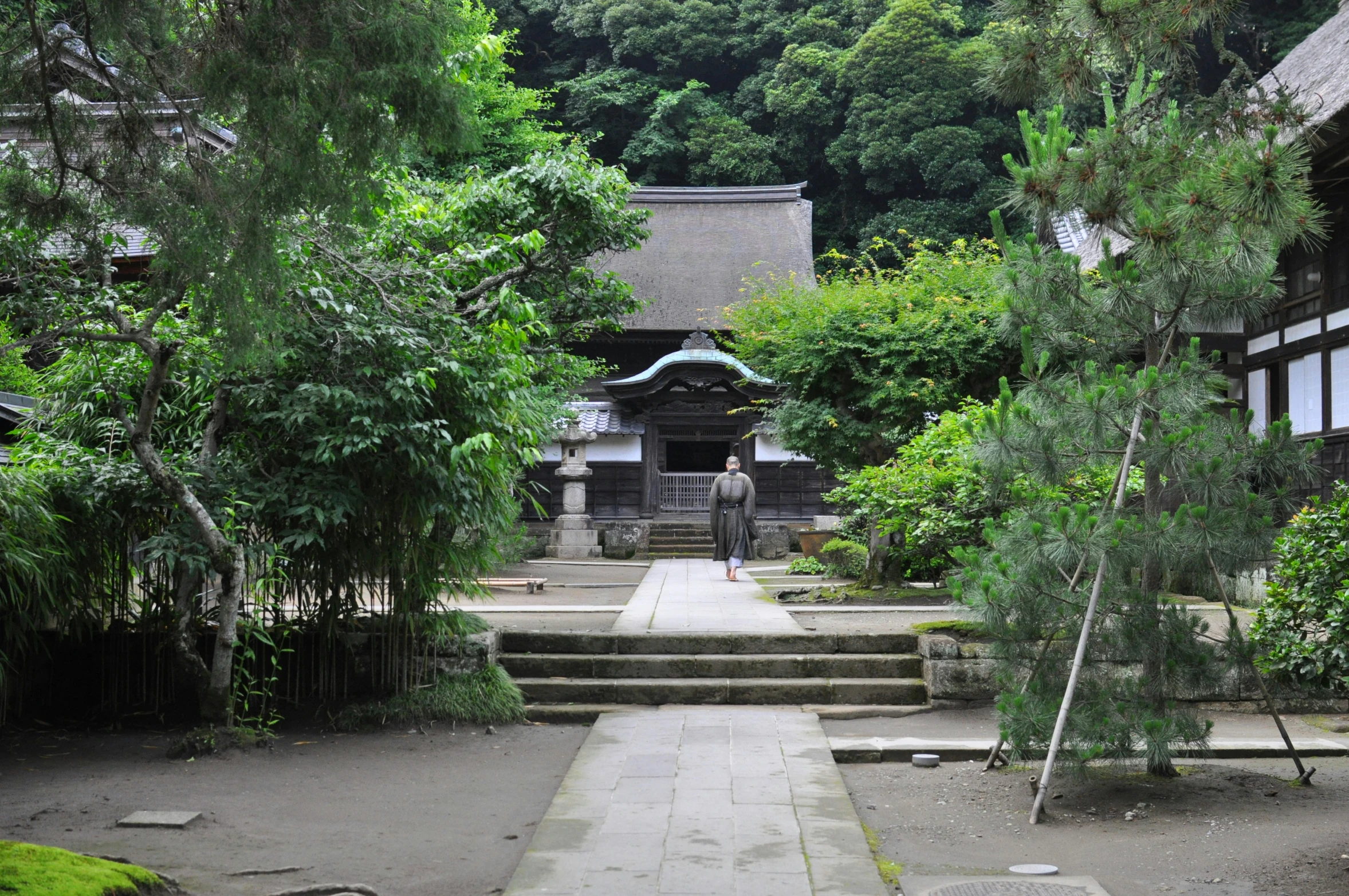 stone walkway and steps leading to some buildings in the woods