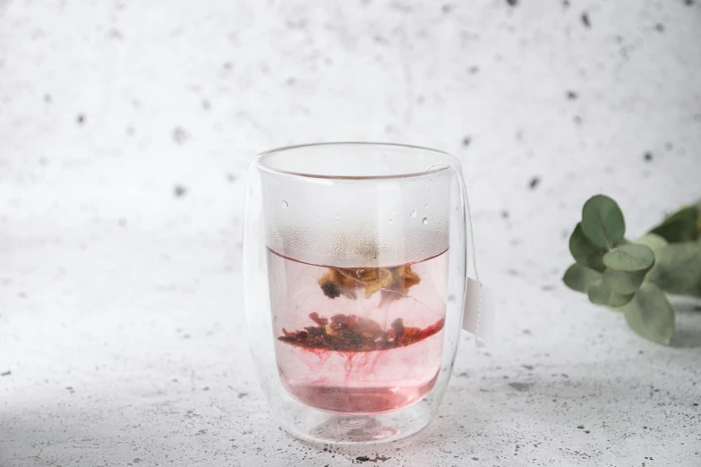 a glass with some stuff inside on a table