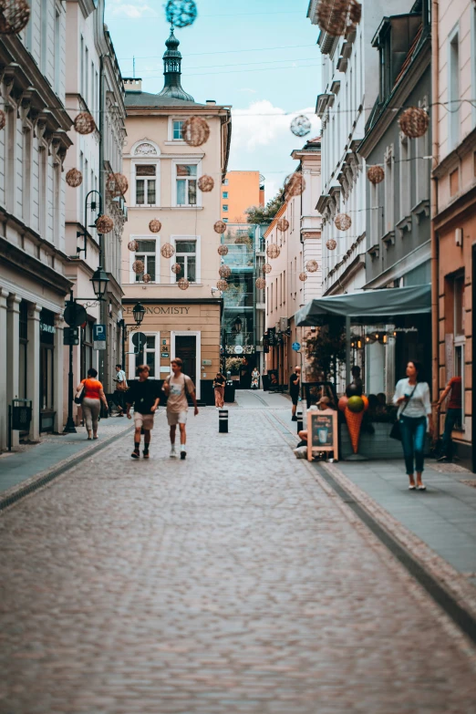 some people walk along the sidewalk in a town