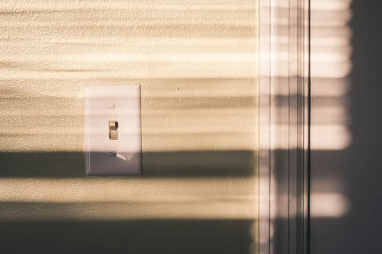 a wall light switch sitting next to a window