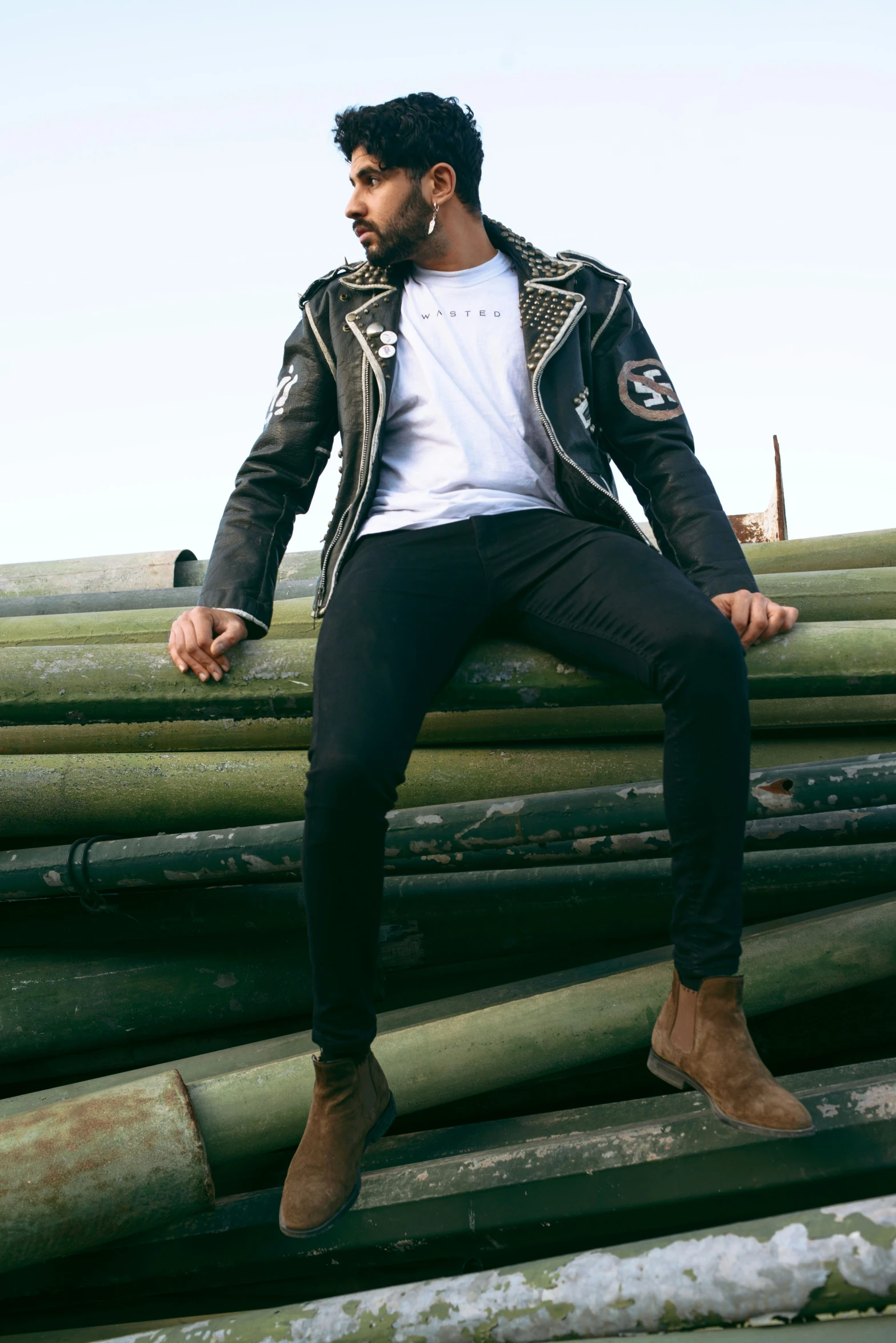 a man sitting on top of a pile of logs