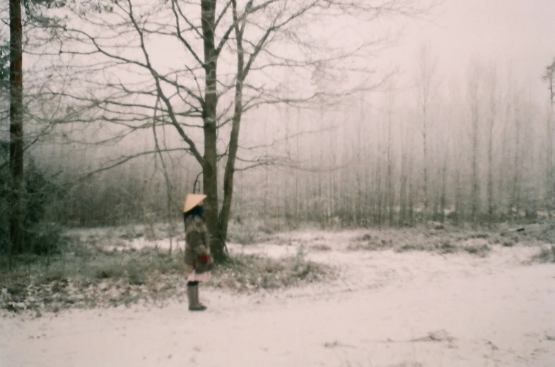 a woman walking across a snow covered ground