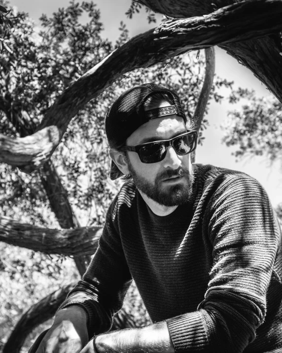 black and white pograph of a man in sunglasses riding a bike