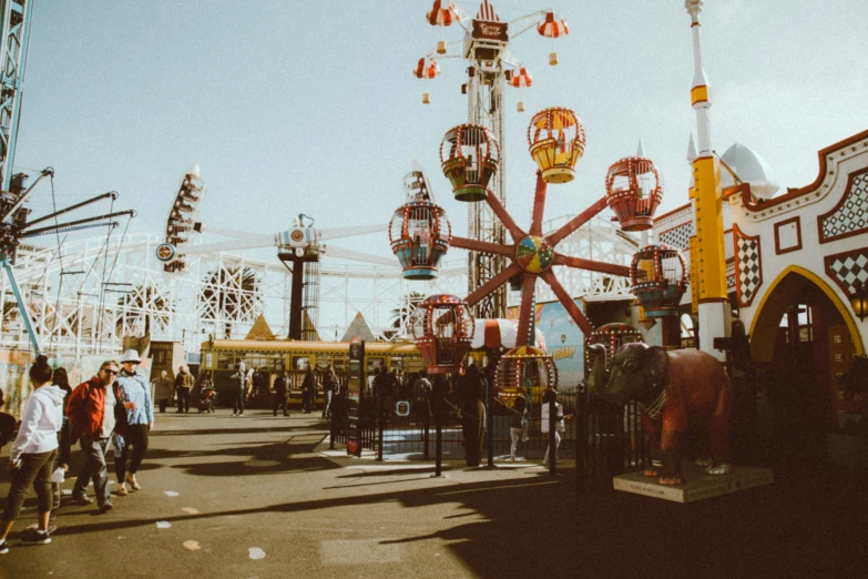 people in front of some rides at a carnival