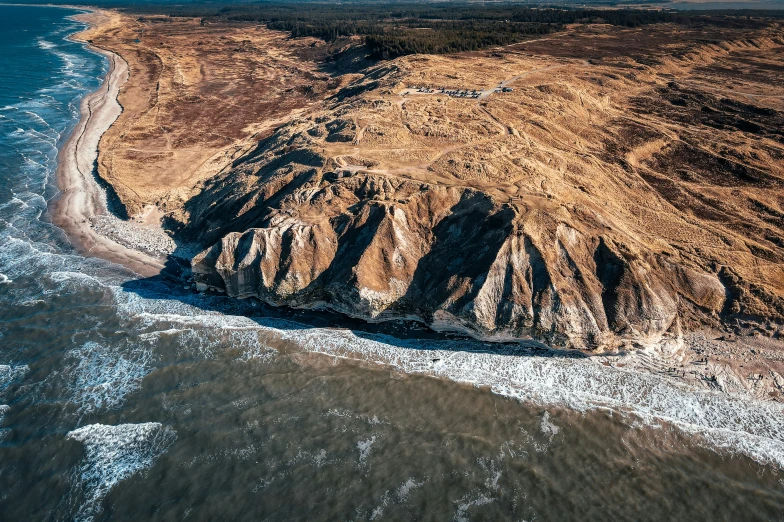 an aerial view of a large sand mountain and body of water