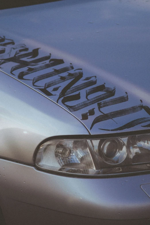 a silver car that has writing on it