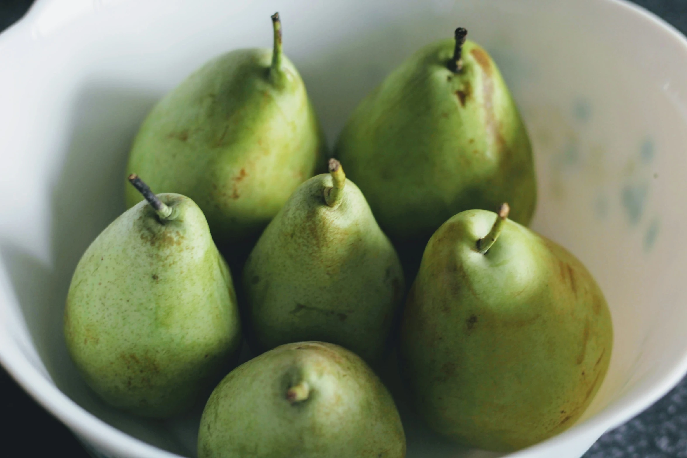 six green pears in a bowl, close up