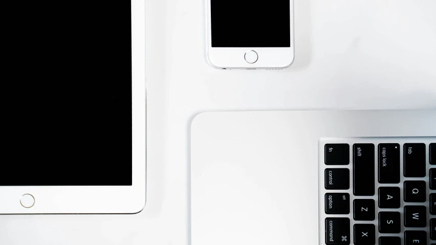 a keyboard, monitor and phone are placed on a desk