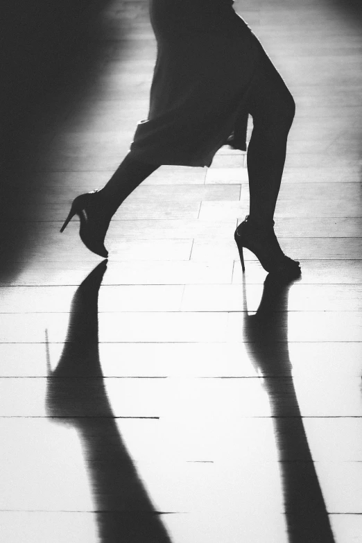 the shadow of a woman's legs and heels