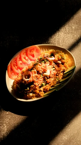 a plate with cooked rice, tomatoes and onion