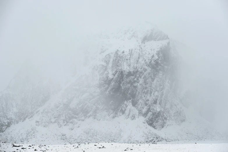 a person skiing in heavy snow near a mountain