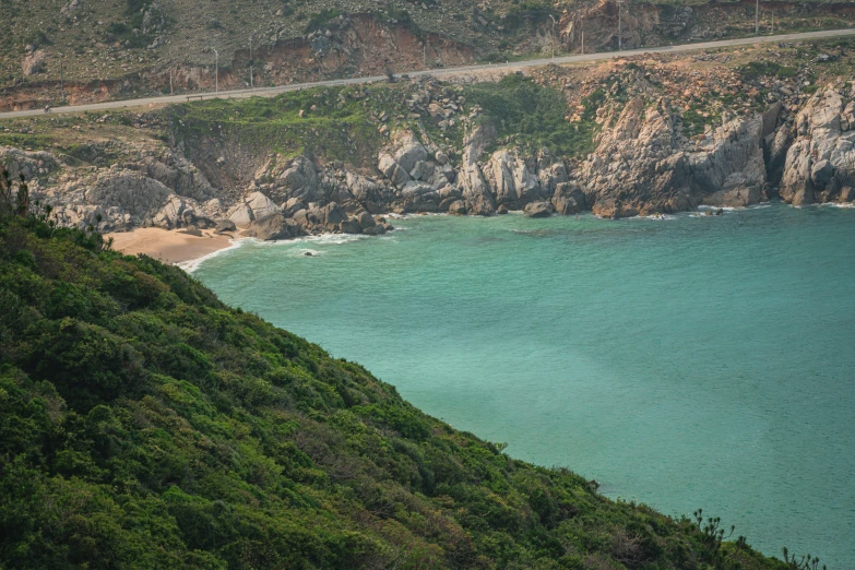 a road going down a hillside to the water