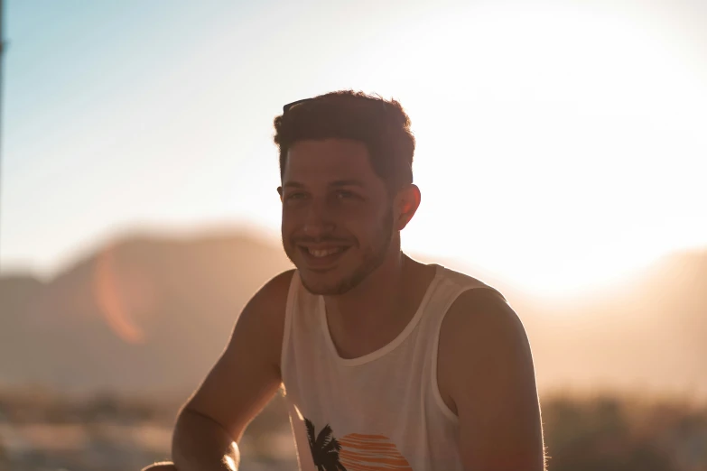 a man smiles for the camera on a beach